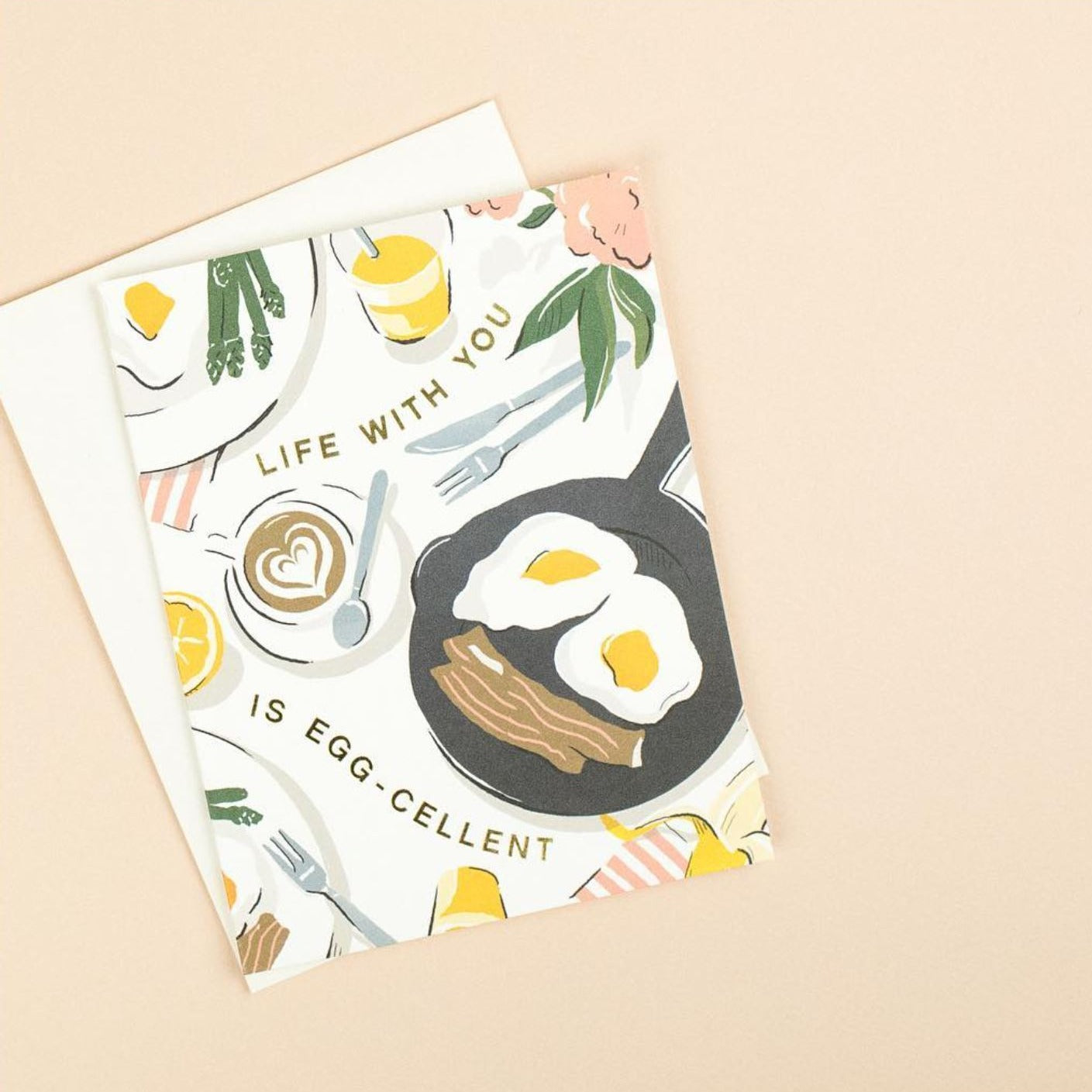Illustrated 'Just Because' card on warm white premium cardstock, featuring a breakfast tablescape of eggs, bacon, and a latte with the text 'Life With You Is Egg-cellent.
