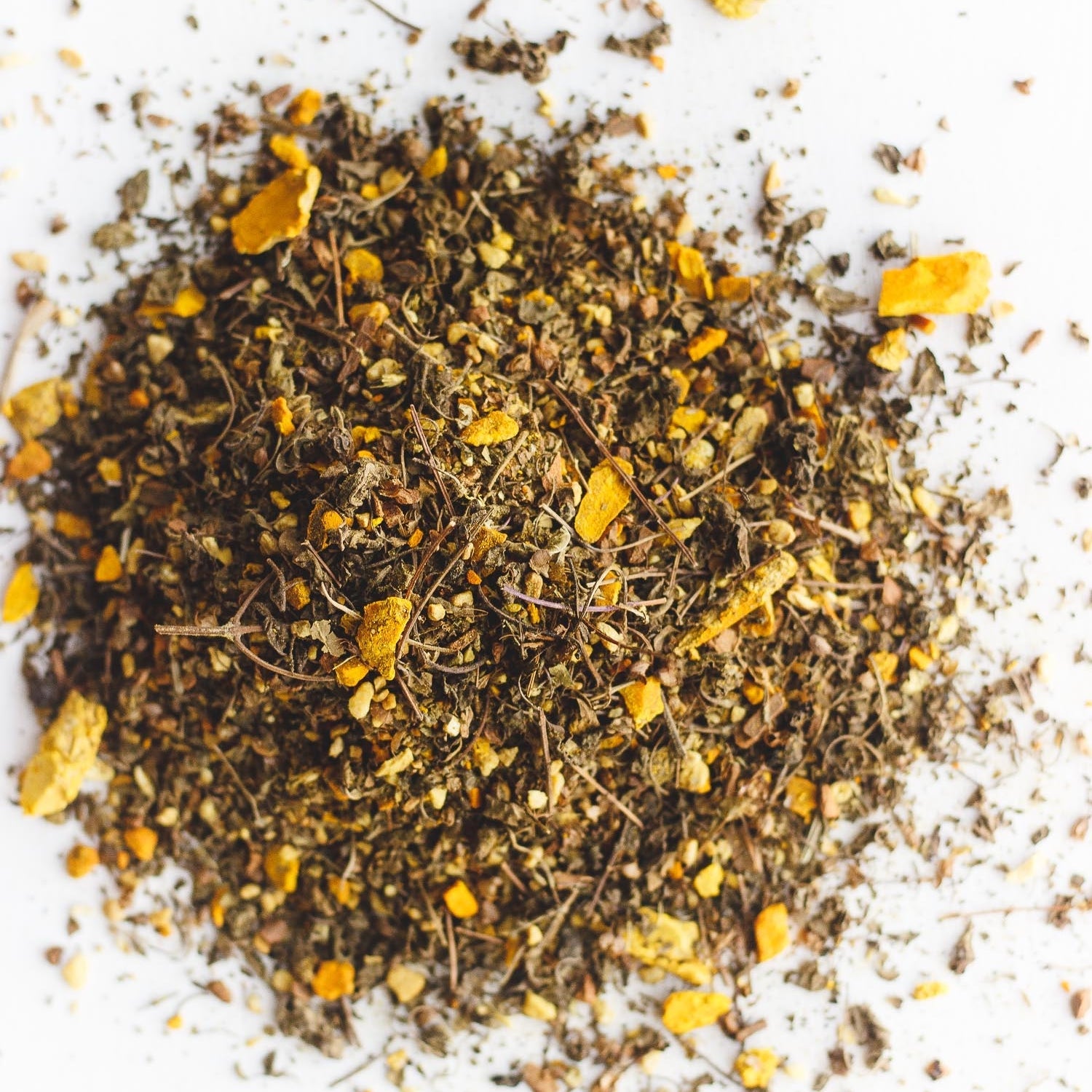 Pile of loose leaf Big Heart Tea Co.'s Cup of Sunshine, an organic blend featuring turmeric, ginger, tulsi, Malabar peppercorn, and cinnamon. Known for its anti-inflammatory benefits, immune-boosting properties, and digestive aid.