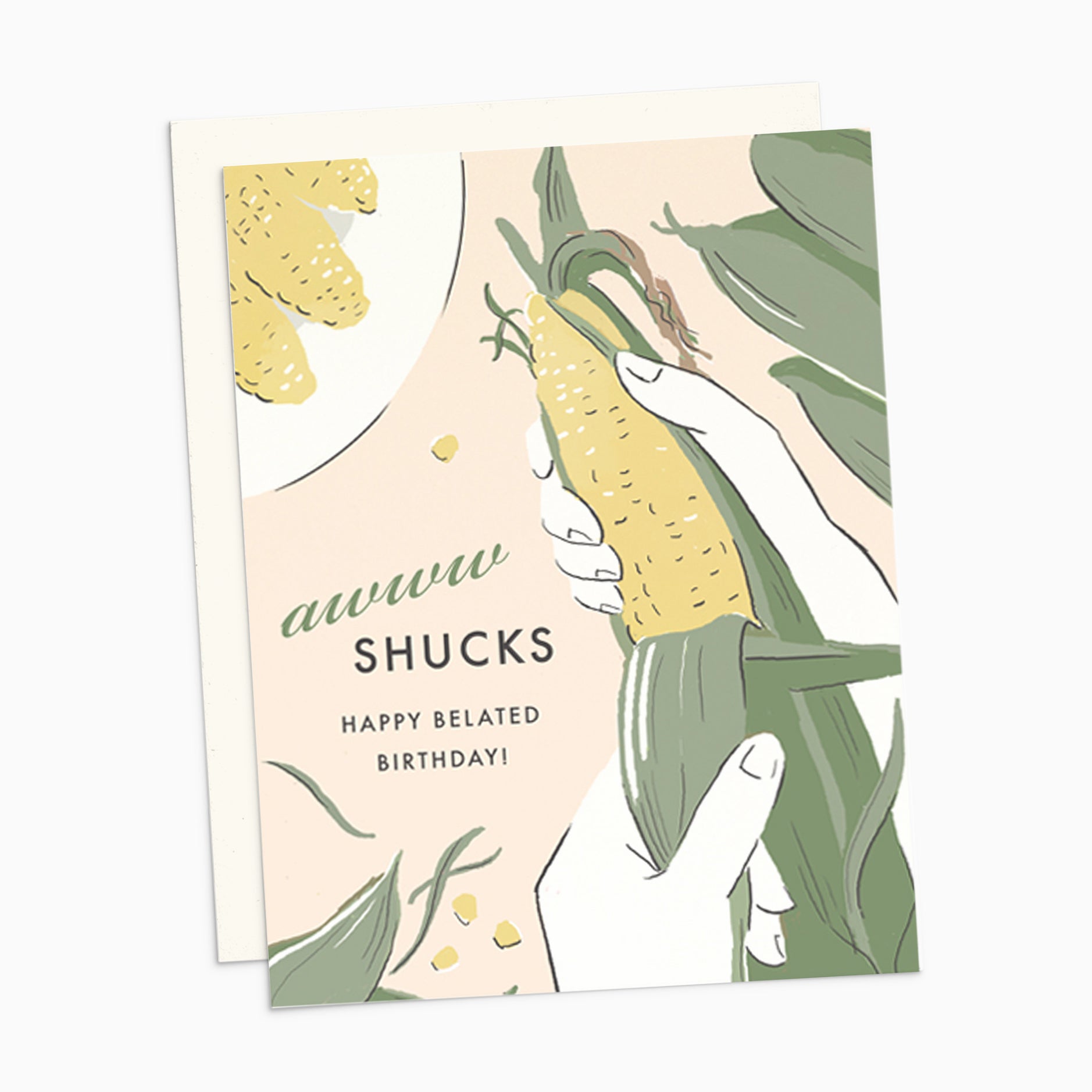 A charming illustrated belated birthday card on premium warm white cardstock, featuring a punny text that reads 'awww shucks, happy belated birthday' alongside a whimsical corn cob being shucked.