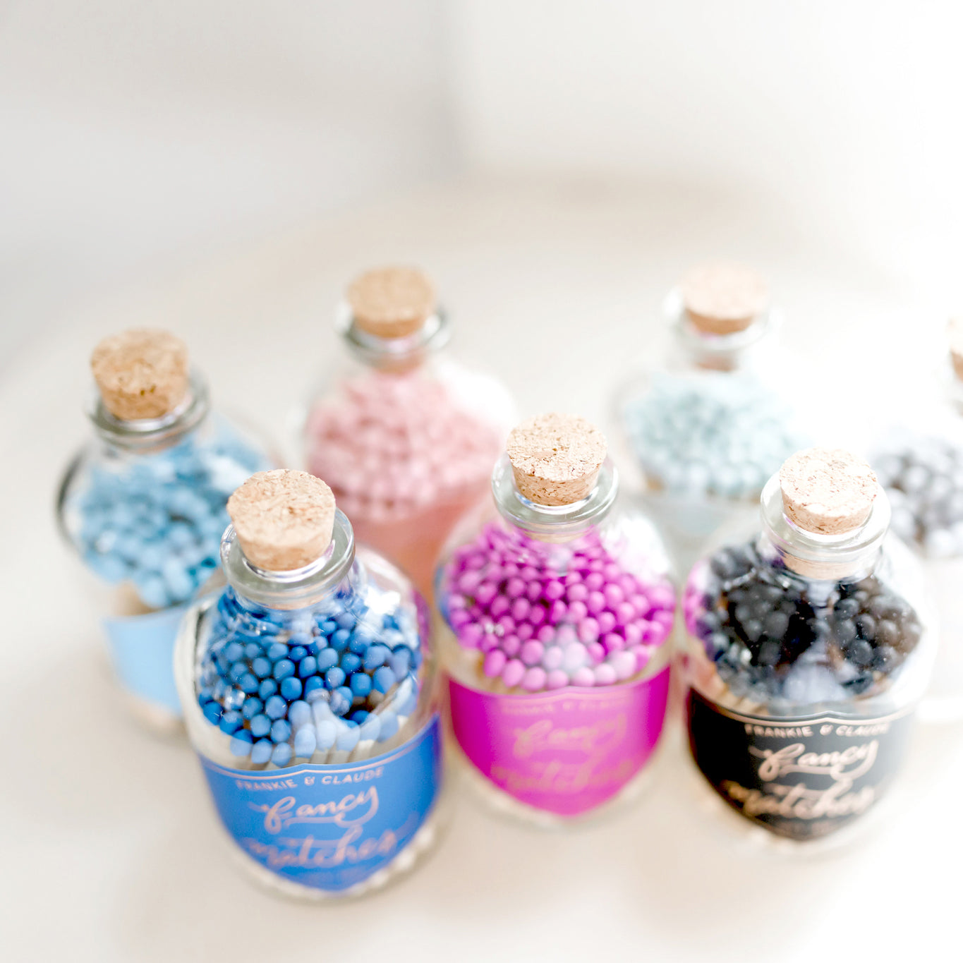 Assorted Fancy Match Jars by Frankie & Claude, featuring various vibrant colors in decorative corked apothecary jars.
